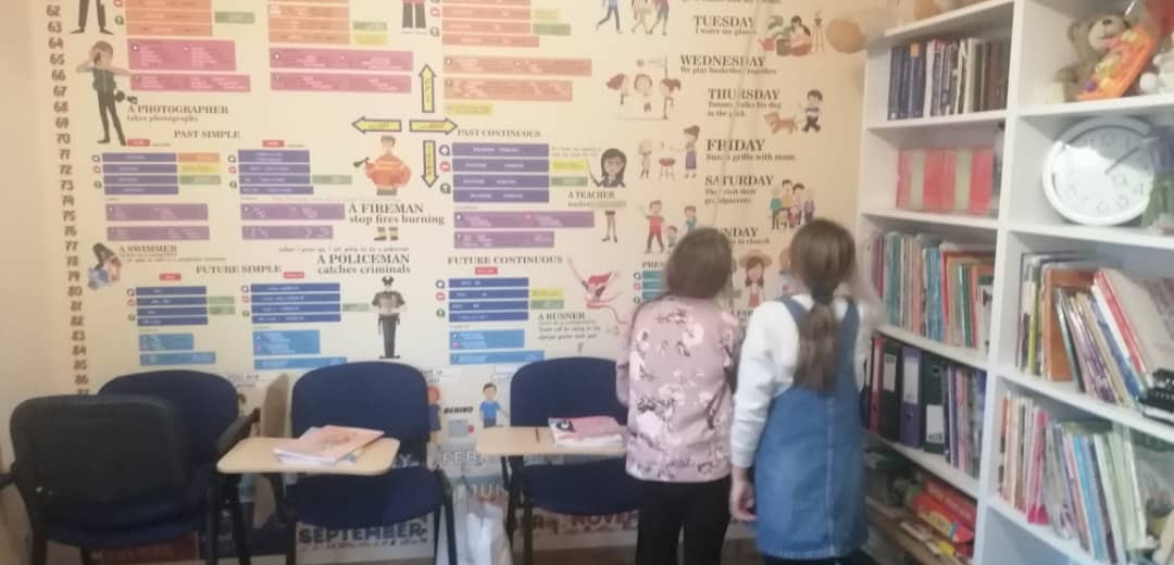Two teenage students study the English grammar mural wall at Open Doors Strzelin